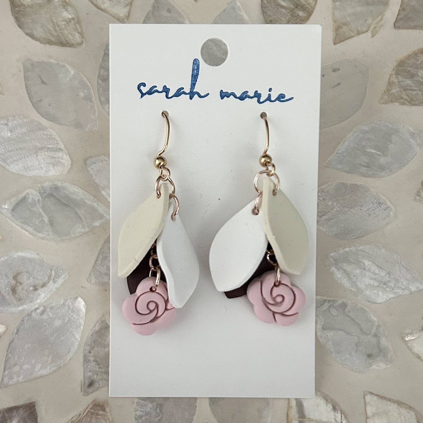 Pair of earrings on a 'Sarah Marie' branded card with a leaf-patterned background