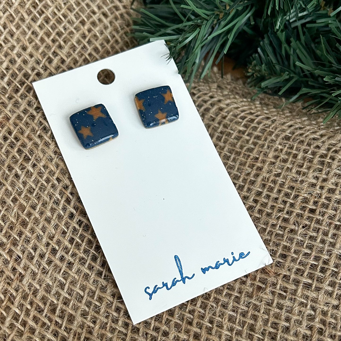 Square navy blue stud earrings with gold stars